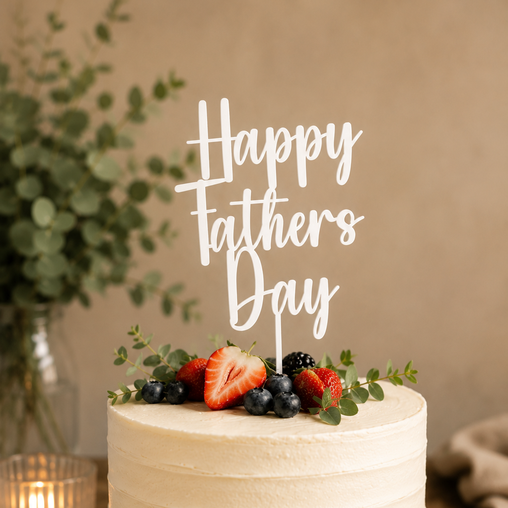 White cake with berries and 'Happy Father's Day' topper on a wooden stand.