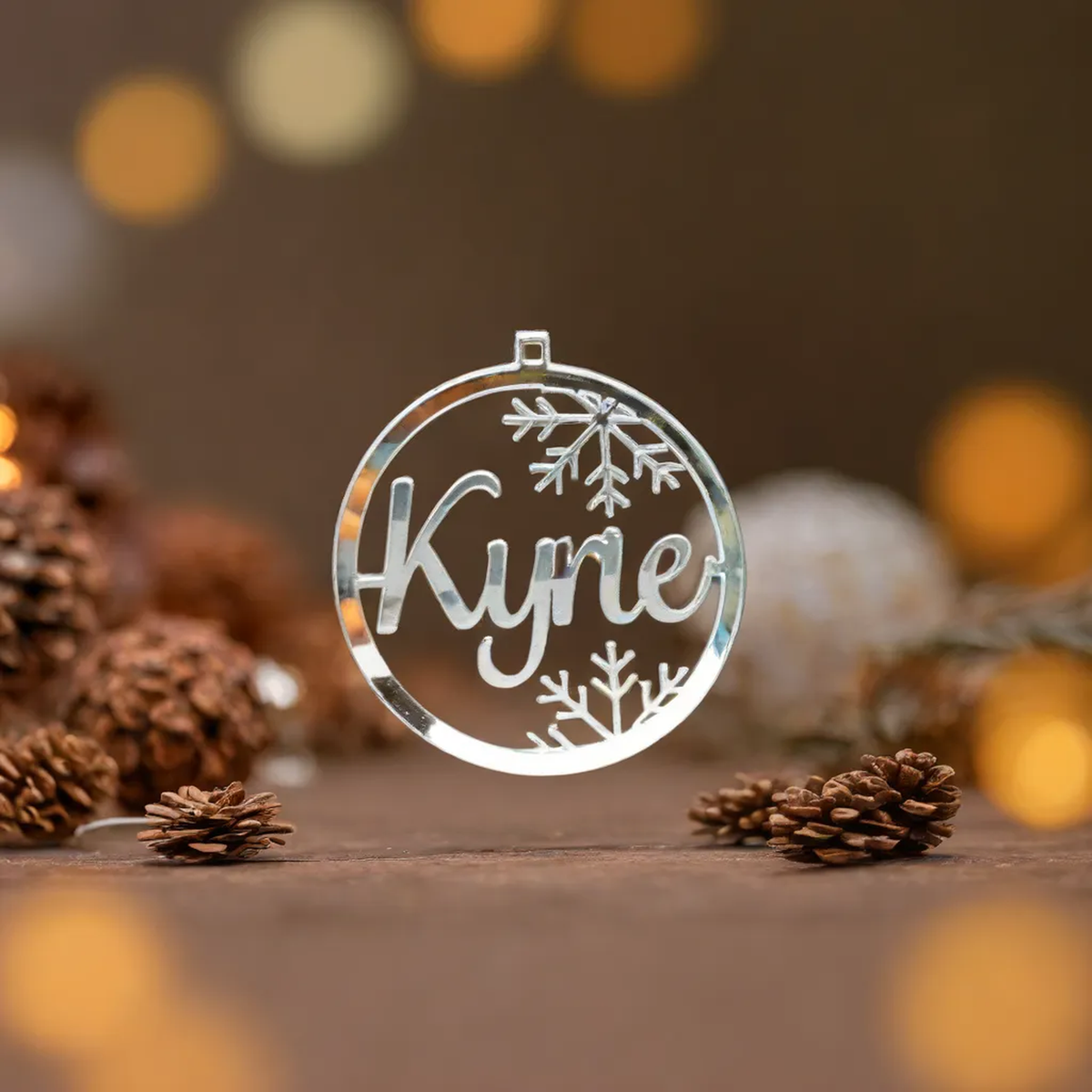 Silver Kylie snowflake name bauble displayed with pine cones