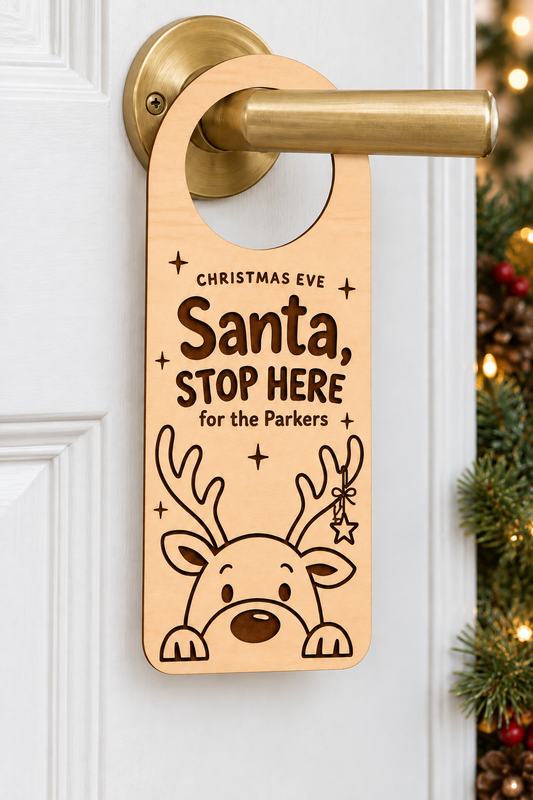 Personalised wooden Santa Stop Here door hanger for the Parkers on a white door, with reindeer engraving and a closed hoop