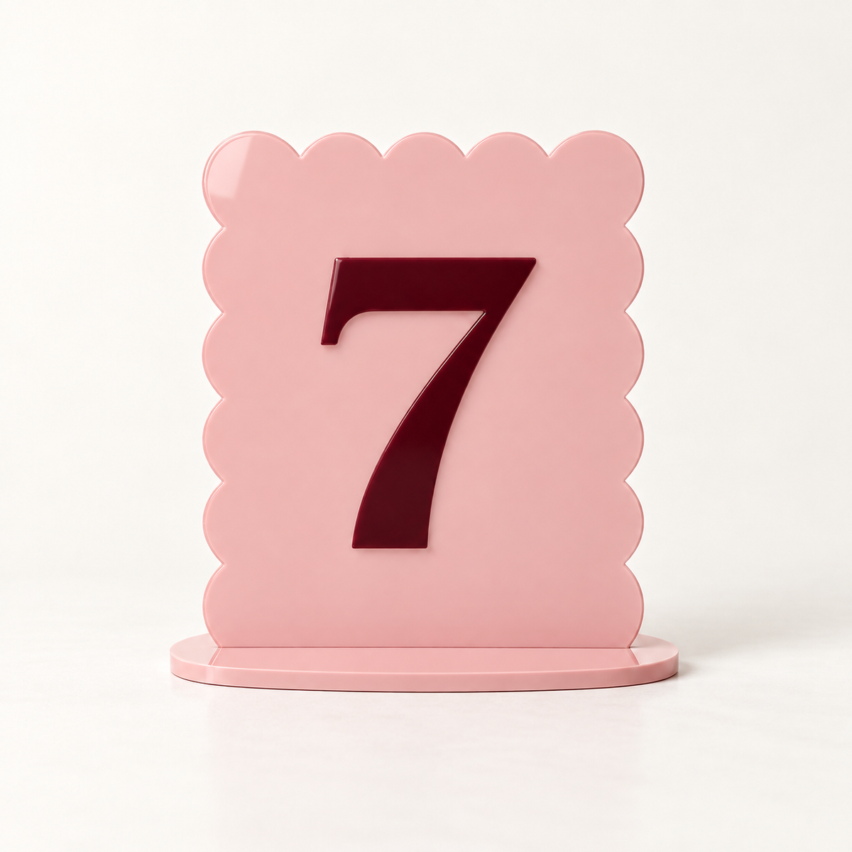 Blush pink scalloped acrylic table number 7 with raised burgundy numeral and matching base